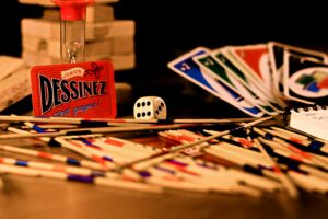 A vibrant arrangement of games, including cards, dice, and sticks, on a table.